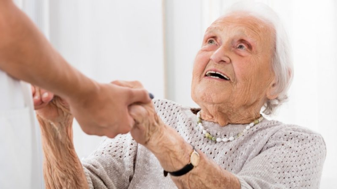 Happy Senior Patient Holding Hands Of Female Doctor In Hospital